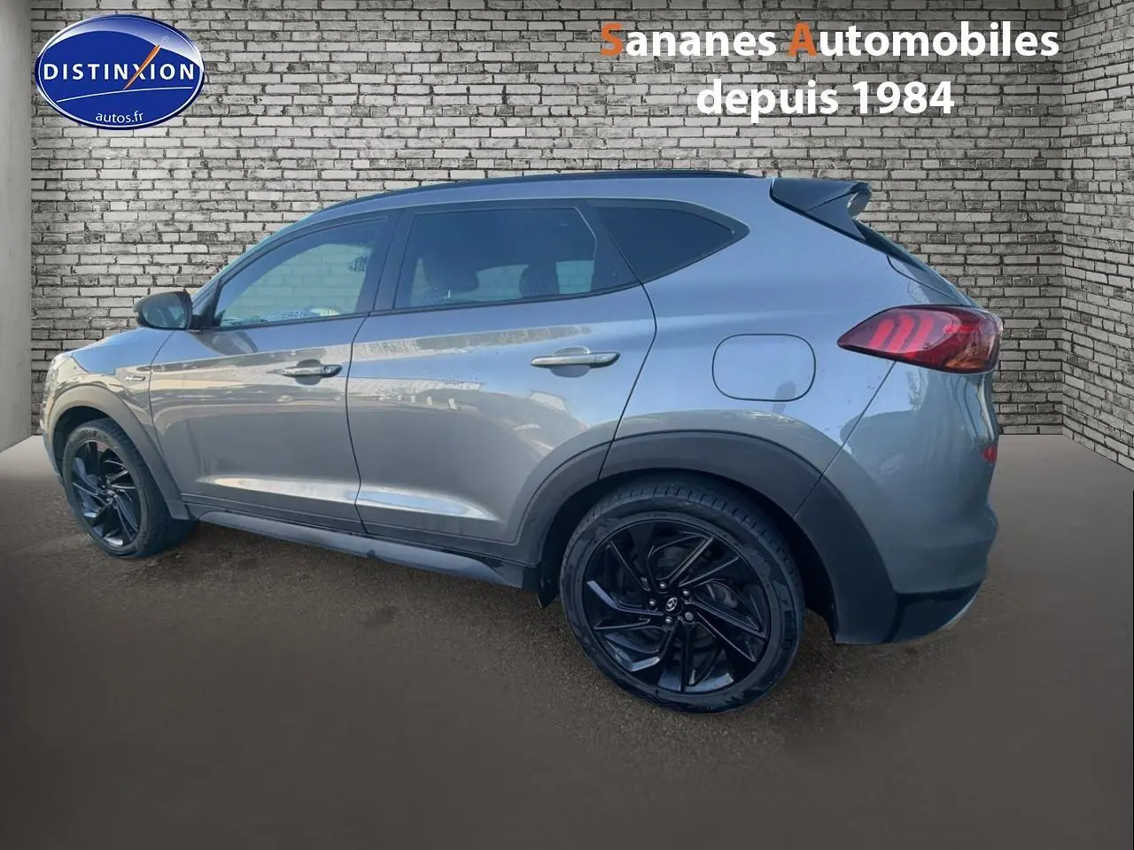 Vue latérale gauche d'un Hyundai Tucson 1.6 Hybrid 136 N Line gris foncé avec jantes alliage noires.
