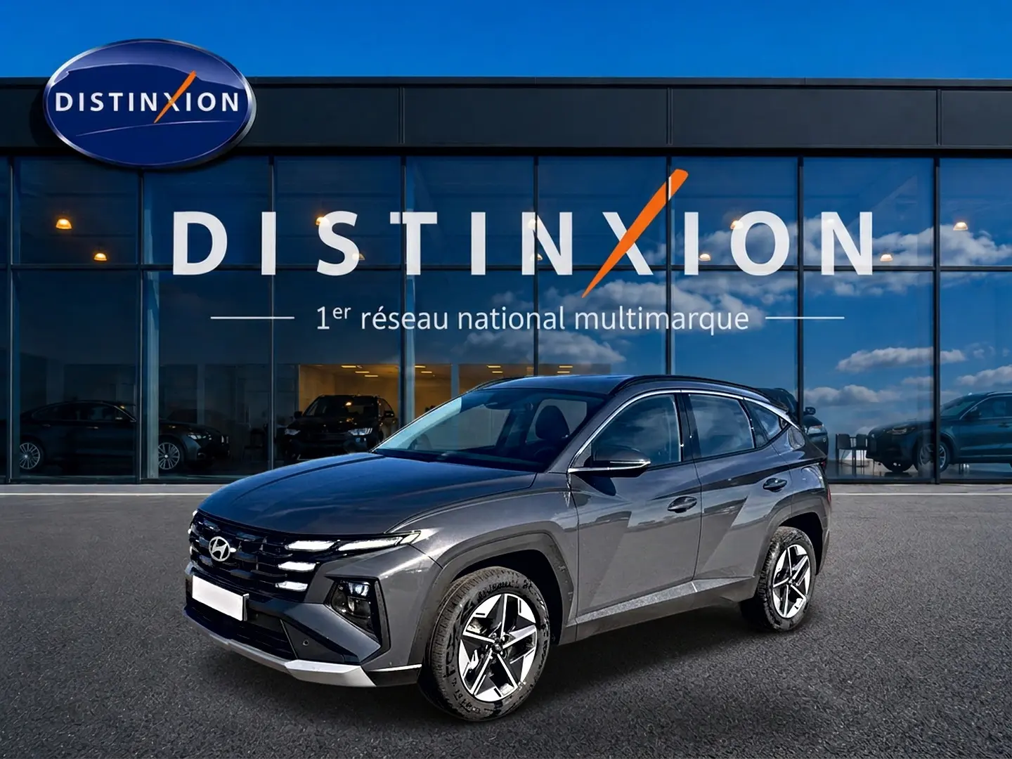 Hyundai Tucson gris ecotronic en 3/4 avant droit, avec jantes alu 18 pouces et calandre distinctive.