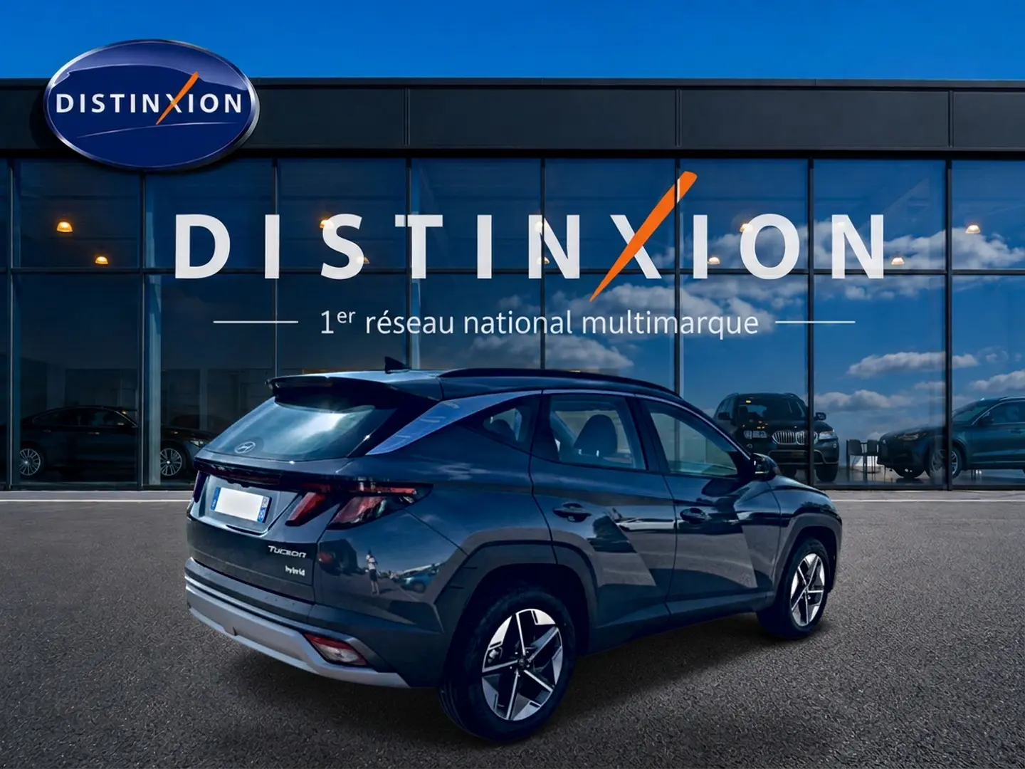 Vue 3/4 arrière droite du Hyundai Tucson gris ecotronic hybride, avec jantes alu et feux arrière LED visibles.