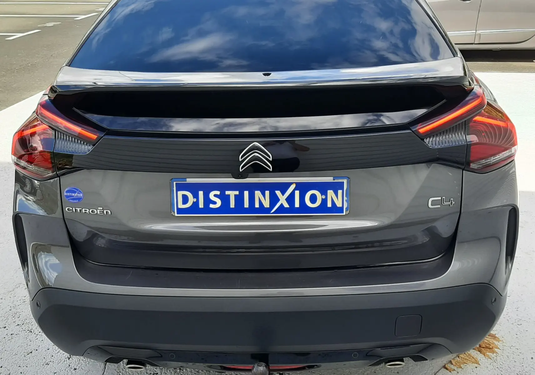 Vue arrière d'une Citroën C4 gris 2024 avec feux LED distinctifs et attelage de remorque visible.