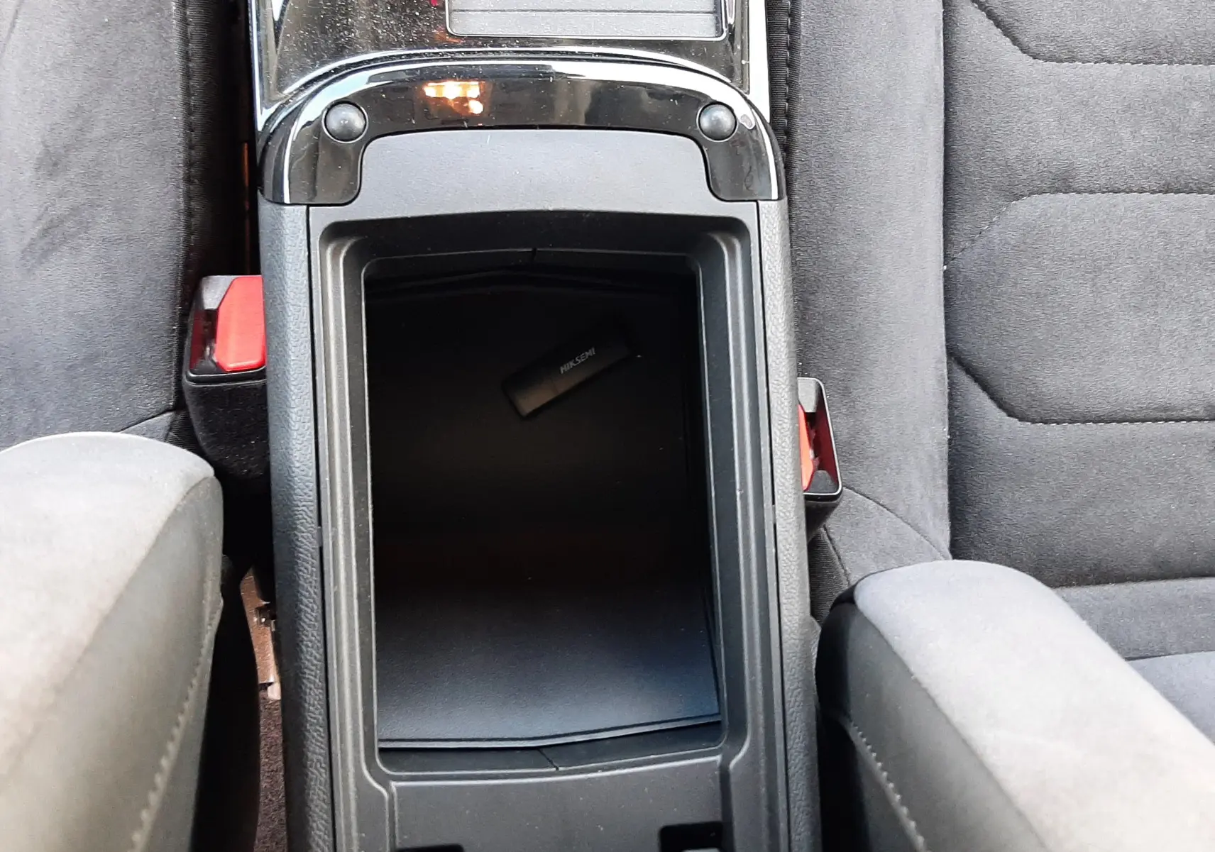 Vue plongeante sur la console centrale noire et les sièges gris de la Citroën C4 1.2 PureTech 2024.