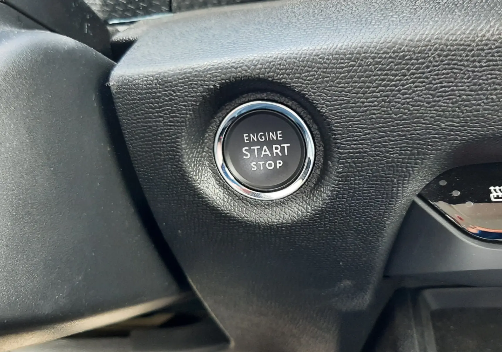 Gros plan sur le bouton start/stop moteur dans l'habitacle noir du Citroën C4 1.2 PureTech 130ch 2024.