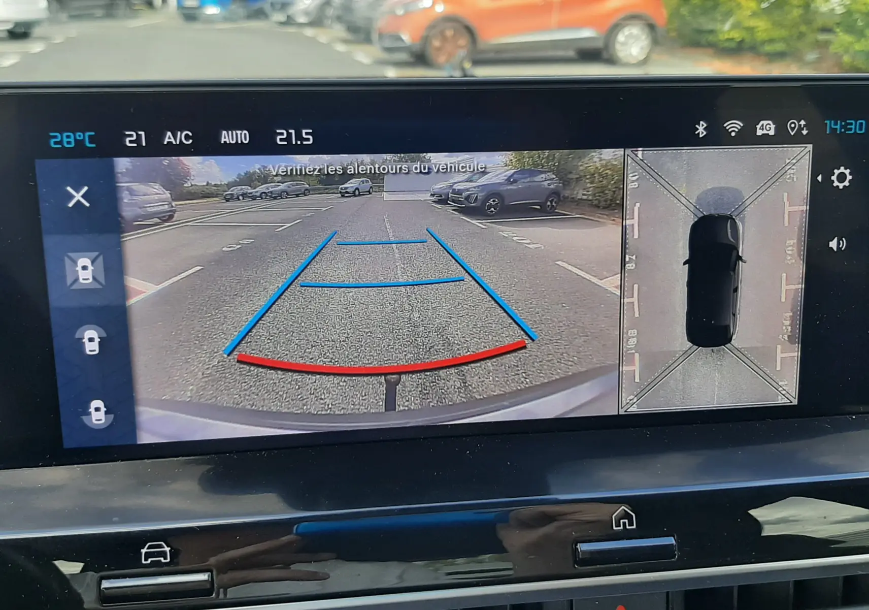 Écran multimédia montrant la caméra de recul et vue 360° d'une Citroën C4 grise en stationnement.