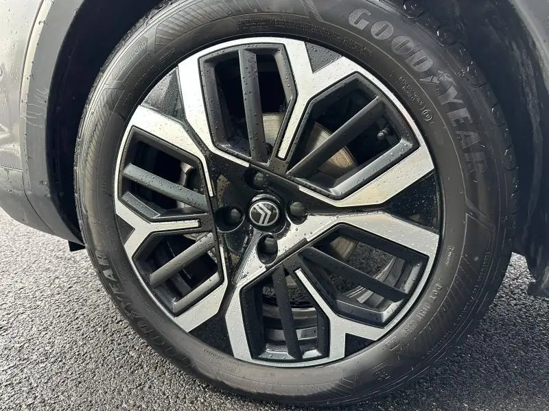 Gros plan sur la jante alliage noire et argentée du Citroën C4 X 2025 en Gris Mercury, avec pneu Goodyear visible.
