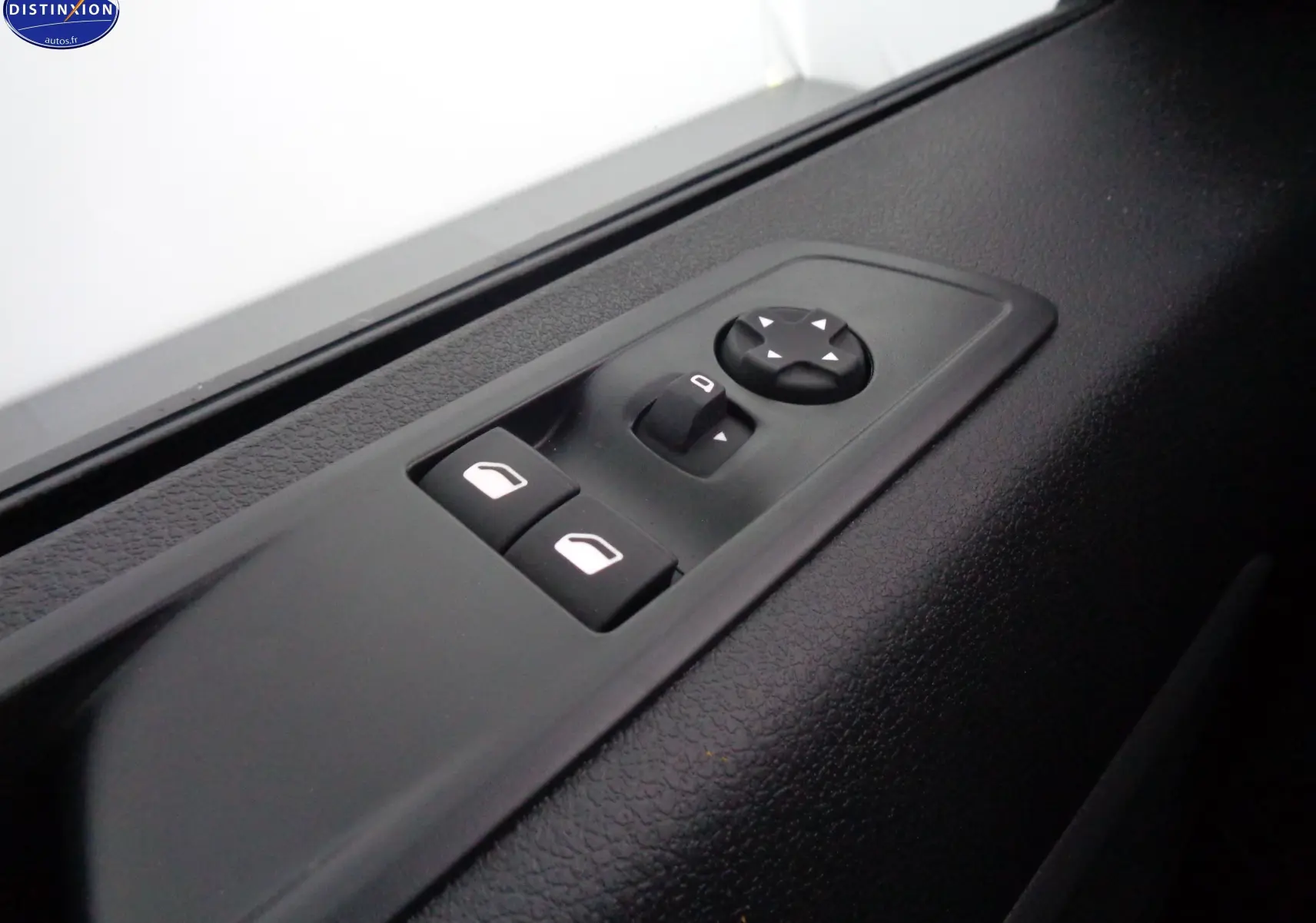 Détail des commandes de réglage des vitres et des rétroviseurs sur la porte côté conducteur du Peugeot Expert gris Artense 2023.