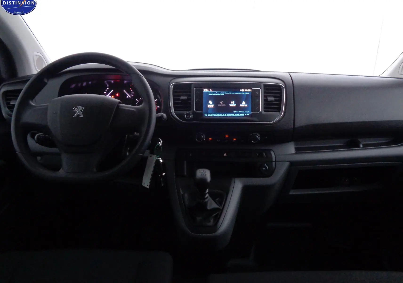Vue intérieure frontale du tableau de bord du Peugeot Expert Cabine Approfondie gris, avec volant, écran tactile et boîte manuelle.