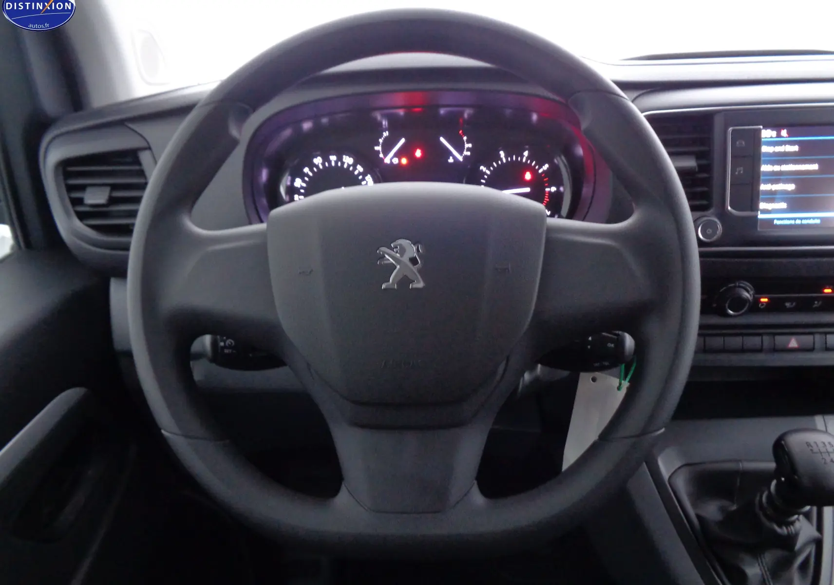 Vue intérieure centrée sur le volant Peugeot d'un Expert Cabine Approfondie 2023 avec tableau de bord et levier de vitesses manuel.