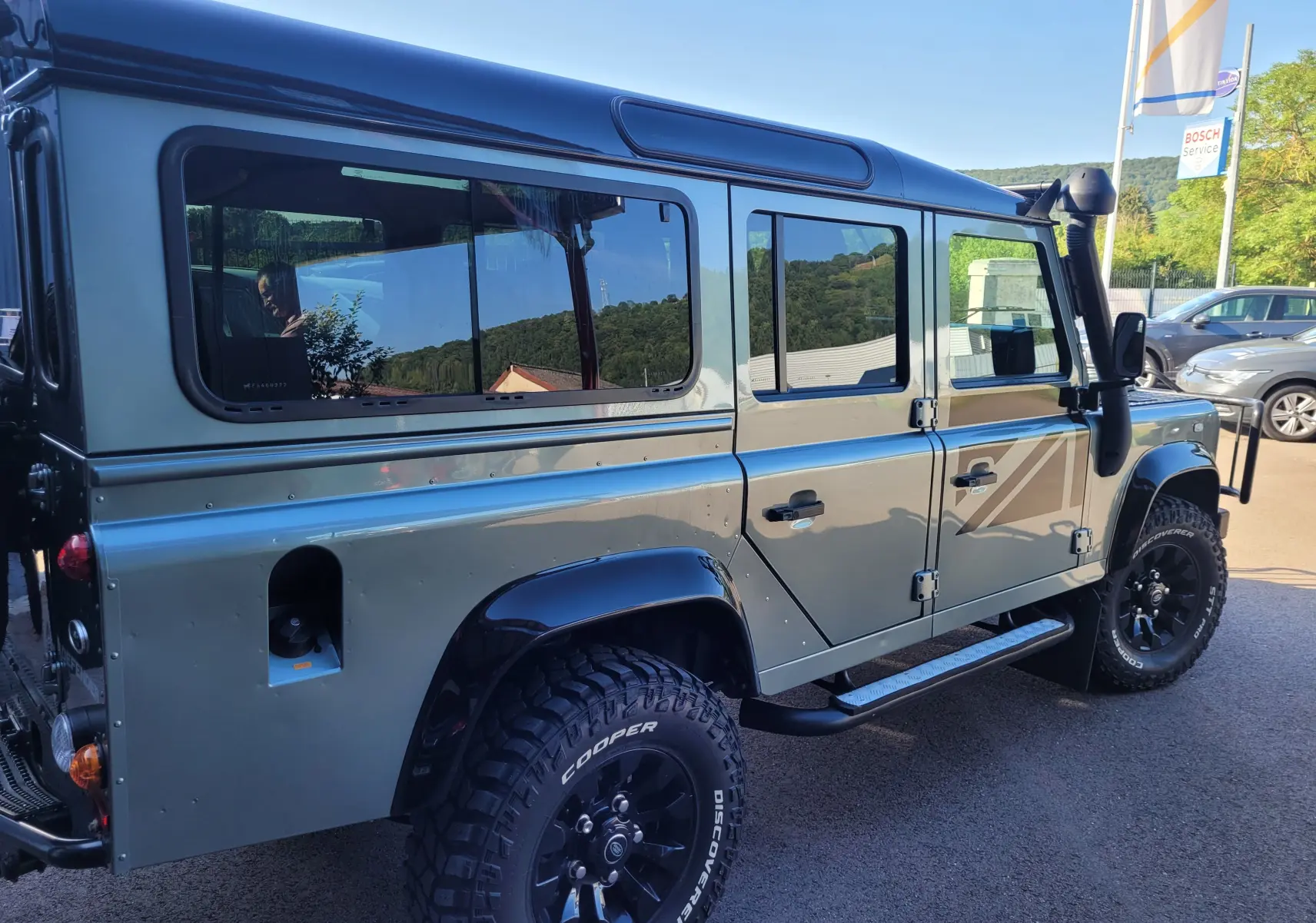 Land Rover 110 Defender Edition Limiter gris, vue côté droit en extérieur, avec pneus tout-terrain et snorkel visible.