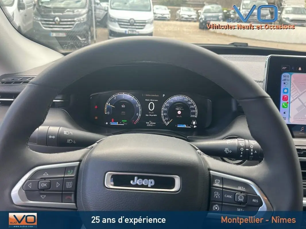 Vue intérieure centrée sur le volant Jeep Compass 2023 avec tableau de bord numérique et écran tactile visible à droite