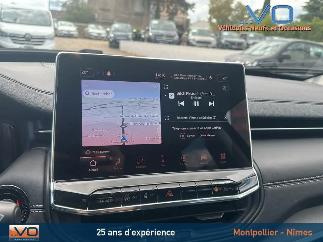 Écran tactile central du tableau de bord du Jeep Compass bleu 2023, avec navigation et musique affichées.