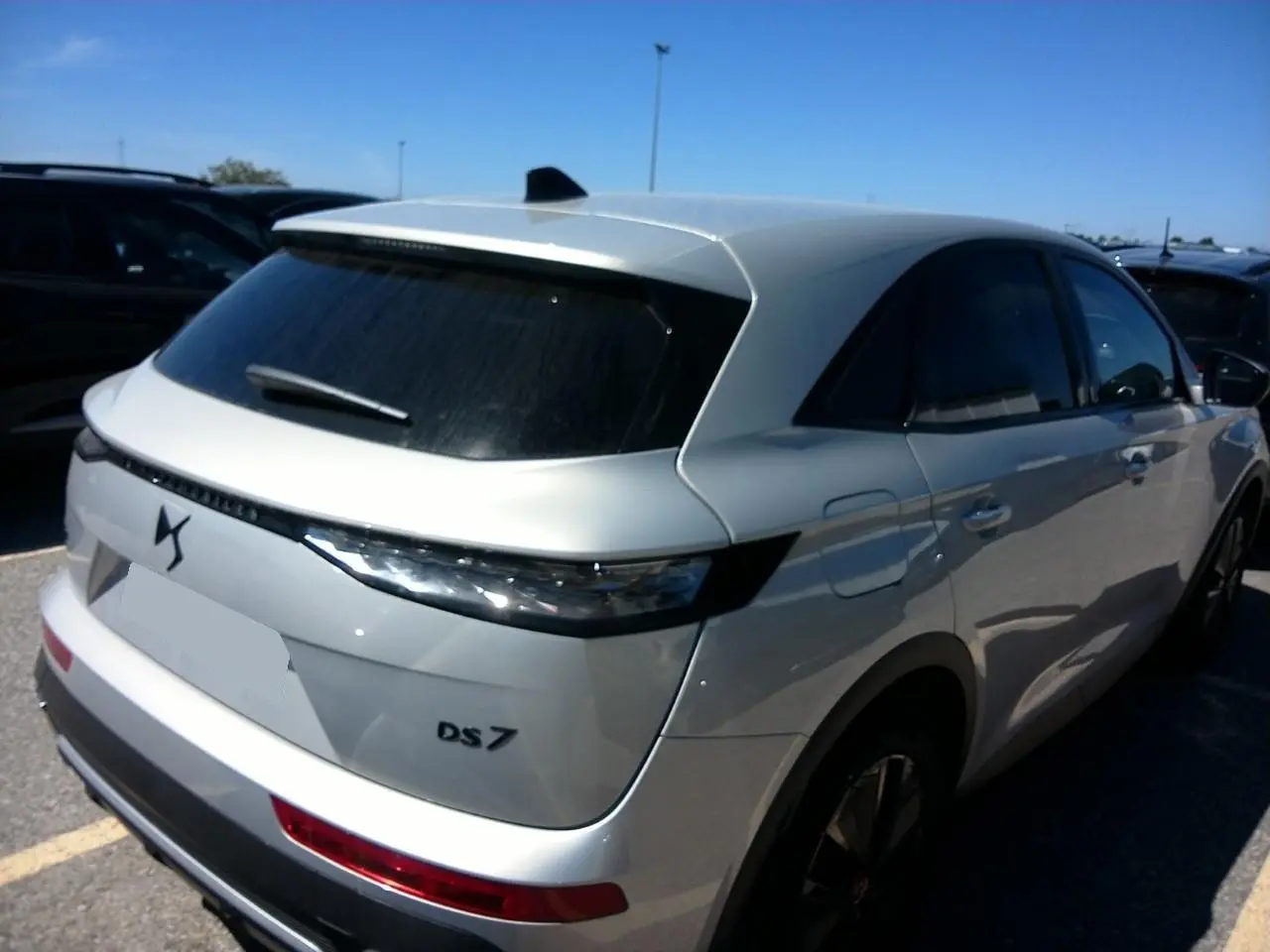 Vue 3/4 arrière droite du DS7 2024 Cristal Pearl avec feux arrière 3D et vitres surteintées.