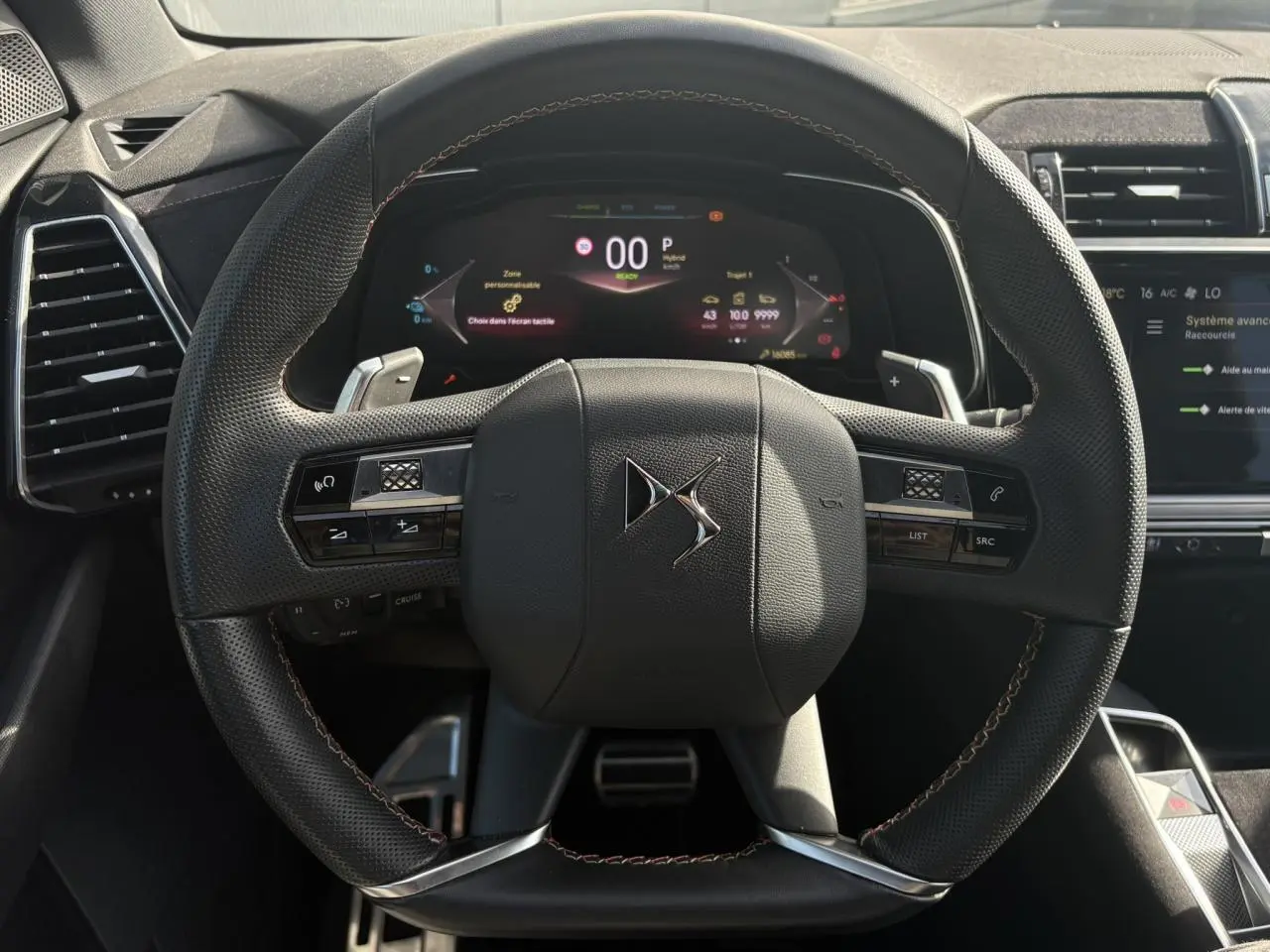 Vue frontale du volant en cuir noir perforé avec surpiqûres Carmin et Or du DS7 1.6 E-Tense 2024, tableau de bord numérique visible.