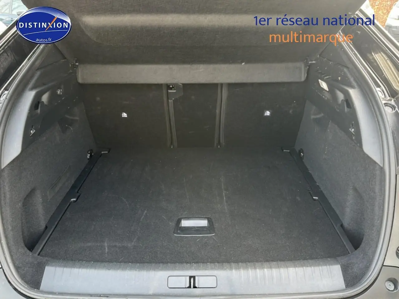 Coffre ouvert du Peugeot 3008 gris titane, vue arrière montrant l'espace de chargement vide et la tablette de séparation.