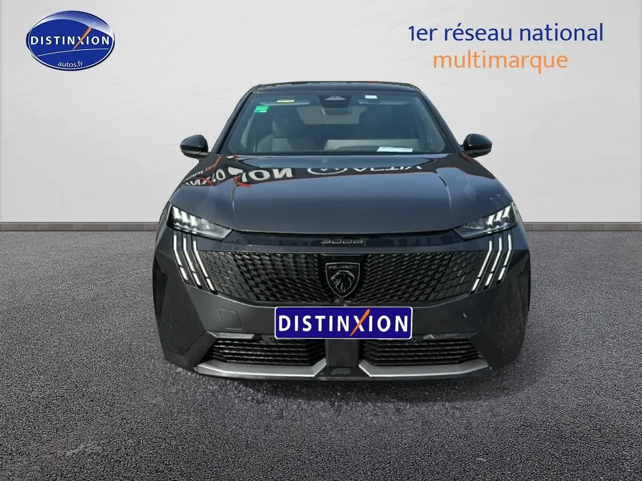 Vue frontale d'un Peugeot 3008 gris titane avec calandre noire et feux LED distinctifs en griffes.