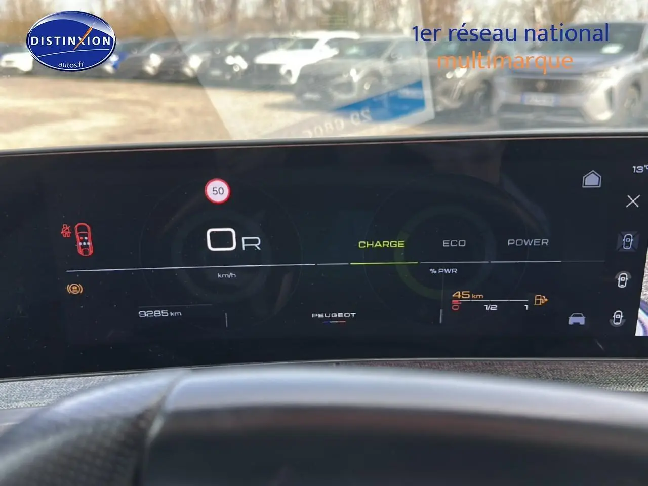 Tableau de bord numérique du Peugeot 3008 gris titane, affichage vitesse, charge et autonomie en vue frontale.