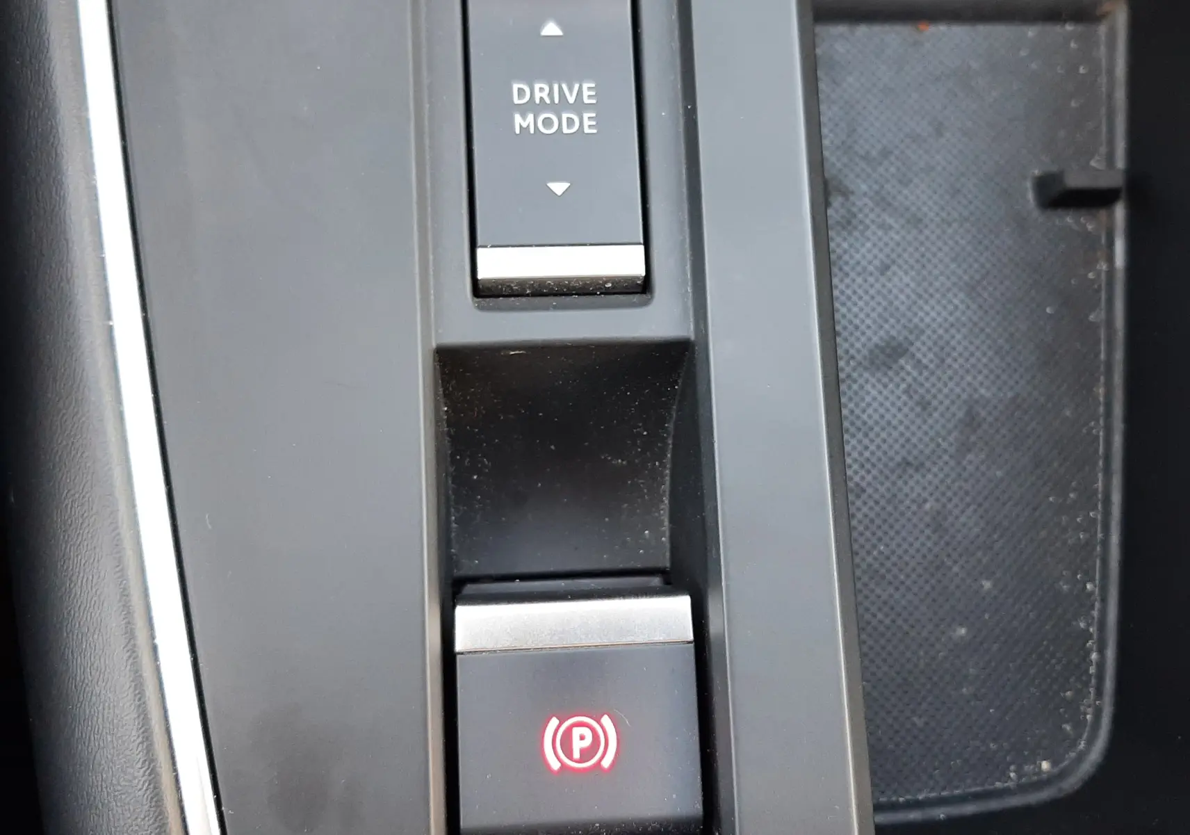 Gros plan sur la console centrale du Citroën C5 Aircross Hybrid gris acier, montrant le bouton Drive Mode et frein à main électrique.