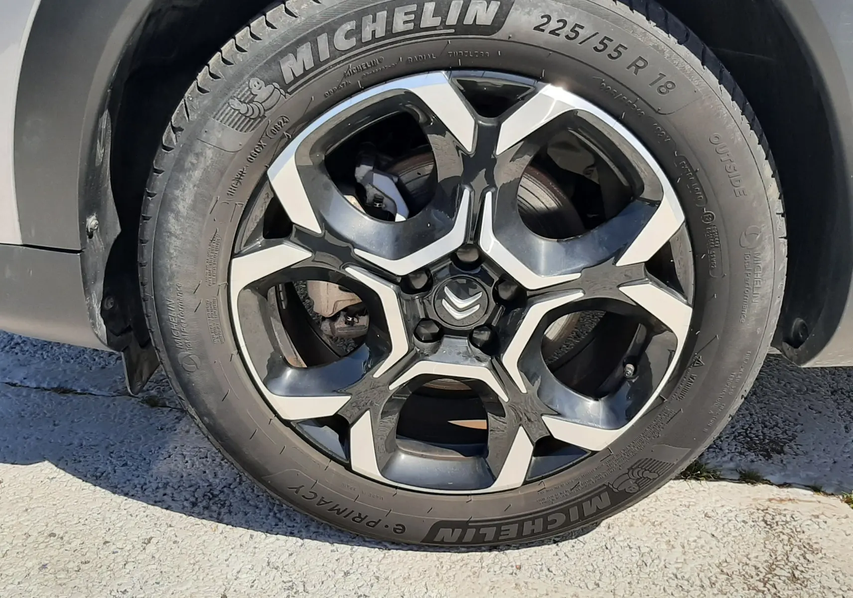 Gros plan sur la roue avant droite du Citroën C5 Aircross Hybrid gris acier avec jante alliage bicolore et pneu Michelin.