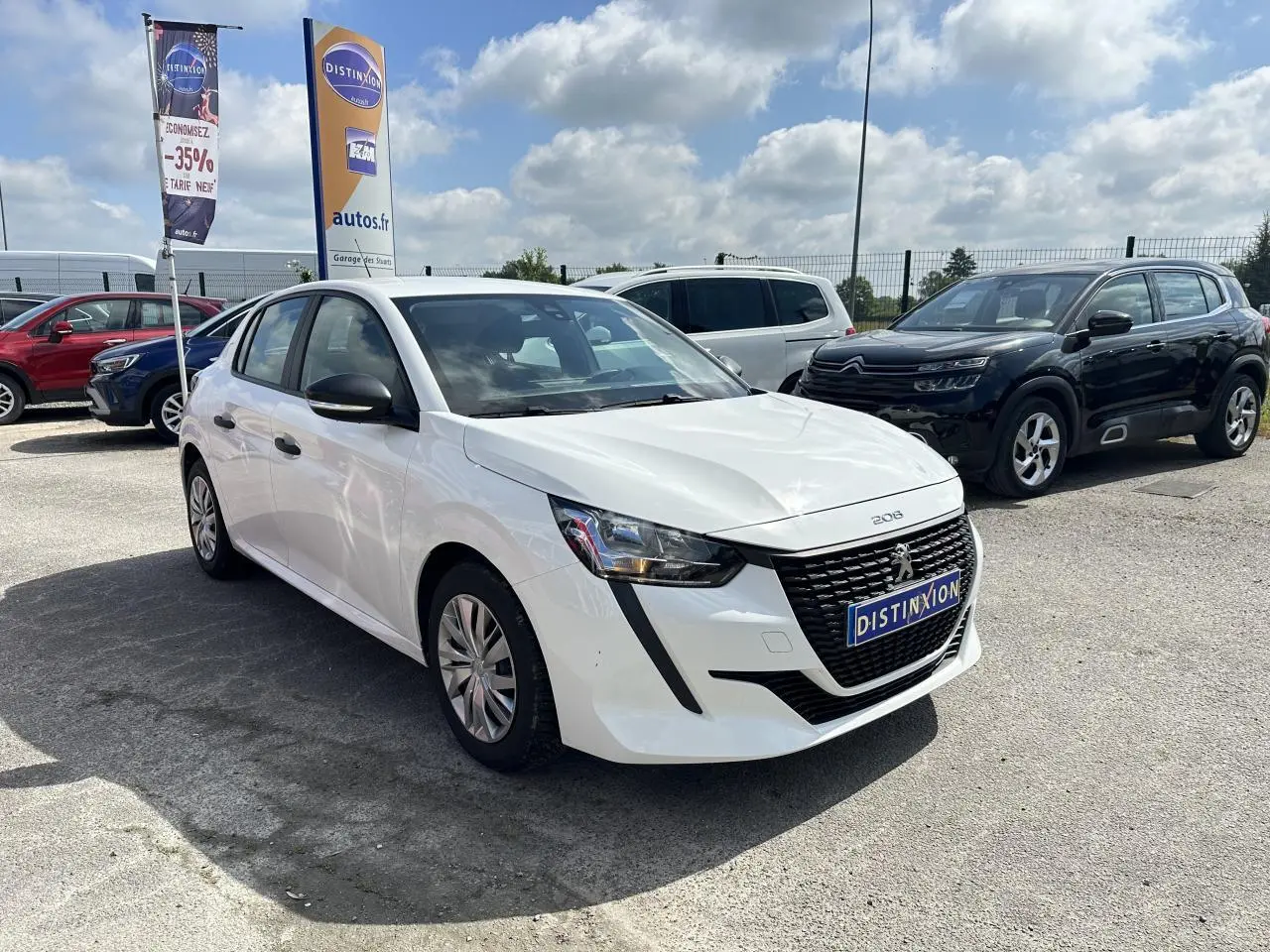 Peugeot 208 blanche vue en 3/4 avant droit, avec calandre noire distinctive et feux avant anguleux.