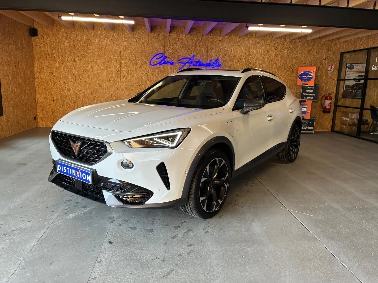 Vue 3/4 avant droite d'un CUPRA Formentor gris 2024 hybride rechargeable, avec jantes noires et détails noirs contrastants.