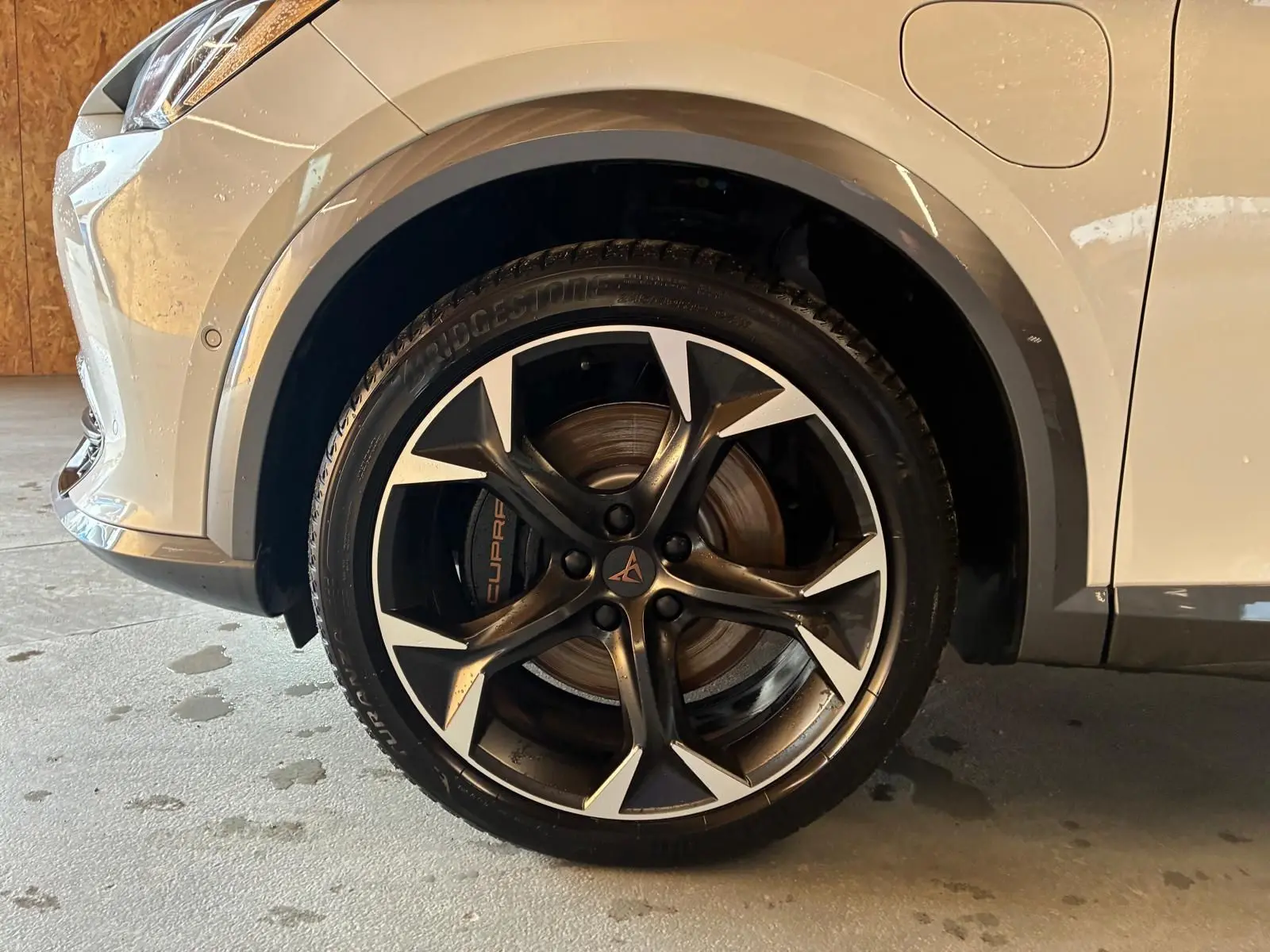 Gros plan sur la roue avant droite gris métallisé d'une CUPRA Formentor 1.4 E-HYBRID 245 avec jante noire et argentée.