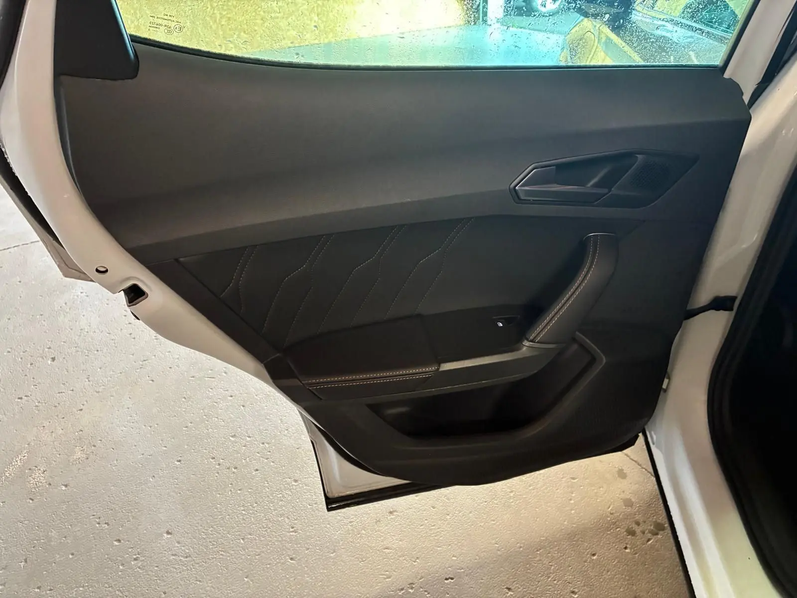 Vue intérieure de la porte arrière gauche noire avec surpiqûres contrastantes du CUPRA Formentor gris 2024.