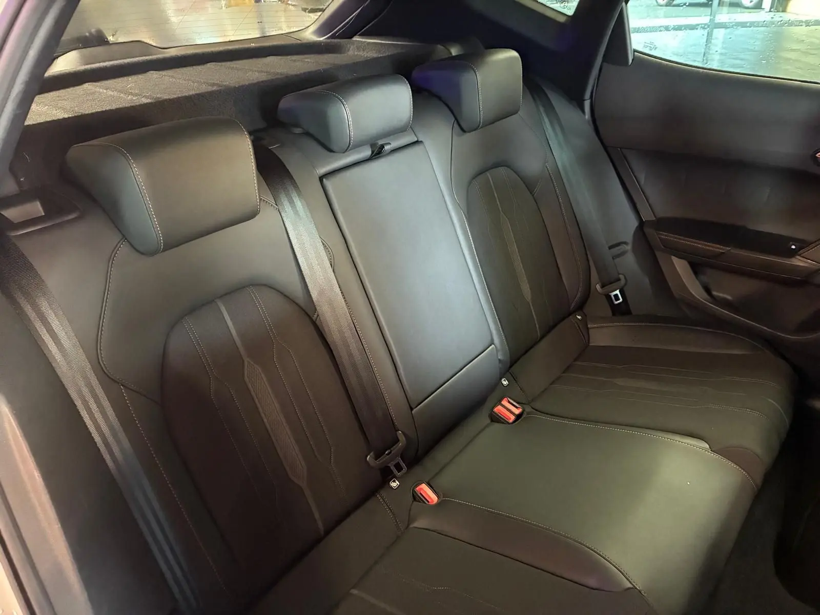 Vue intérieure arrière du CUPRA Formentor 1.4 E-HYBRID 245 DSG6 VZ 2024, sièges arrière noirs en tissu et cuir avec surpiqûres.
