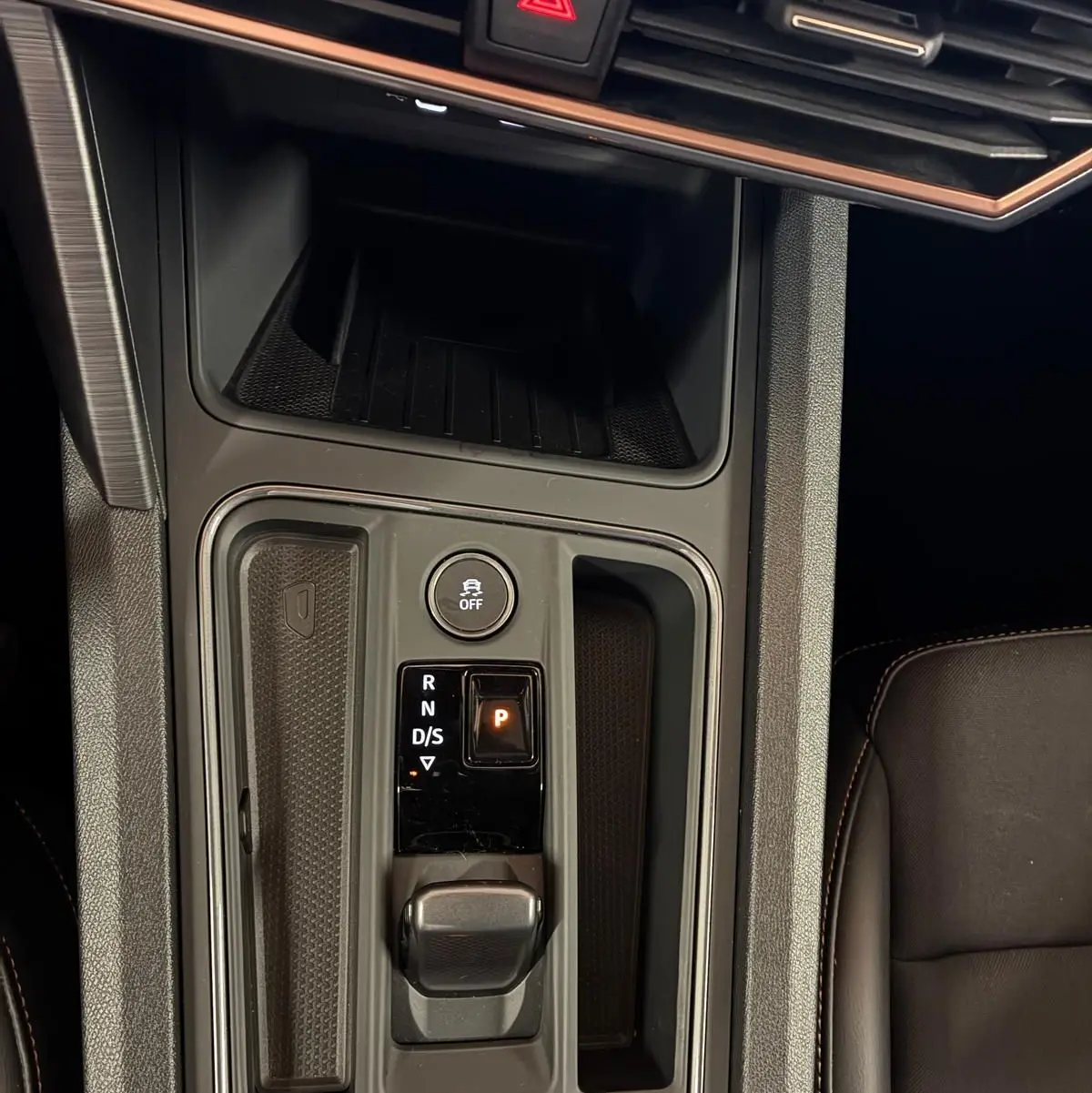Vue plongeante sur la console centrale noire du CUPRA Formentor 1.4 E-HYBRID 2024 avec sélecteur de vitesse électronique et bouton de déverrouillage.