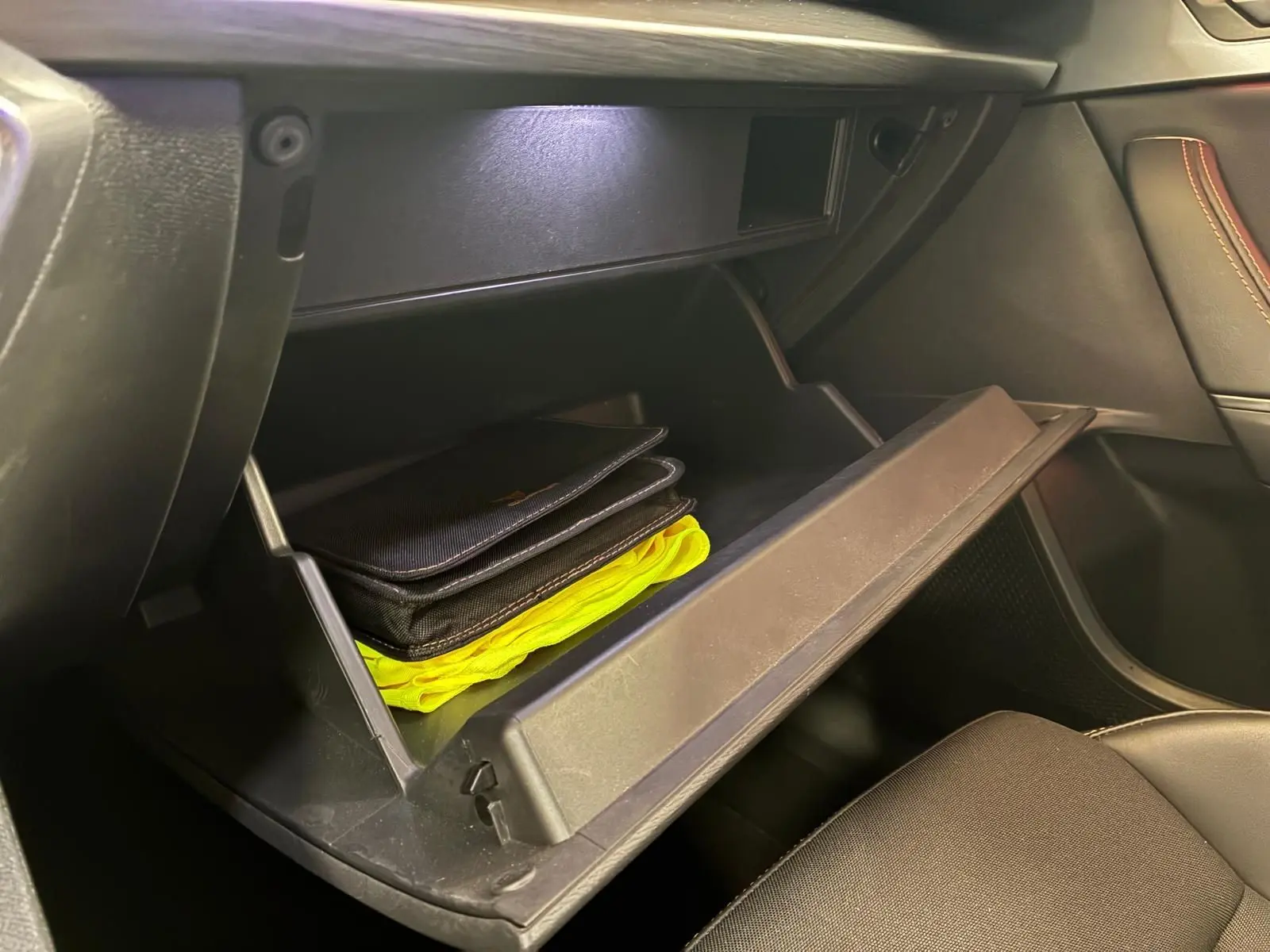 Gant de boîte à gants ouvert côté passager dans l’habitacle noir du CUPRA Formentor 1.4 E-HYBRID 2024.