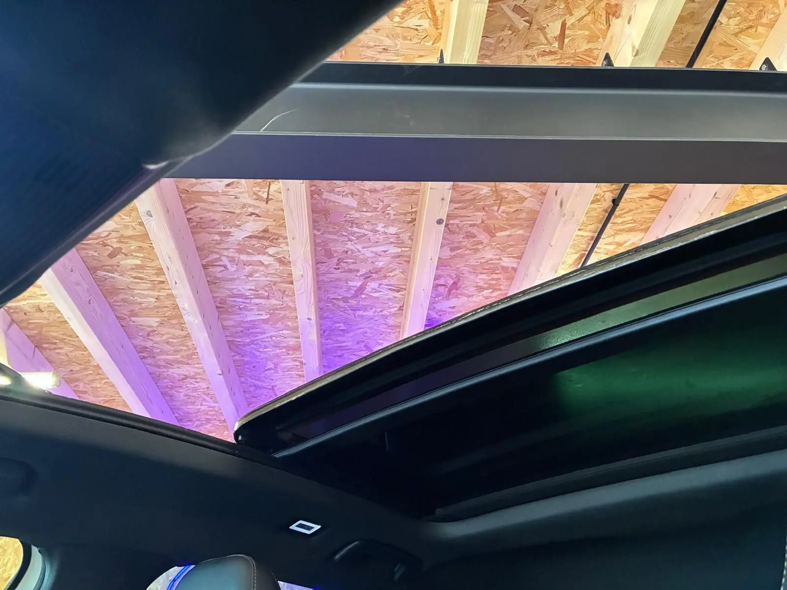 Toit ouvrant panoramique ouvert vu de l'intérieur d'une CUPRA Formentor gris, avec plafond en bois visible à l'extérieur.