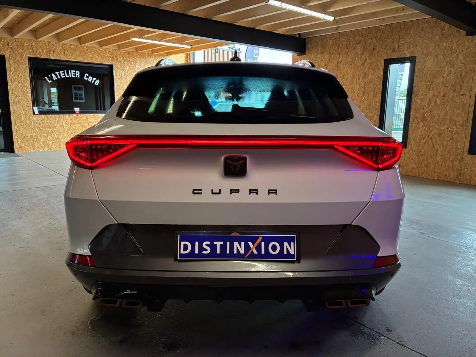 Vue arrière d’un CUPRA Formentor gris 2024 avec feux LED en bandeau et double sortie d’échappement carrée.
