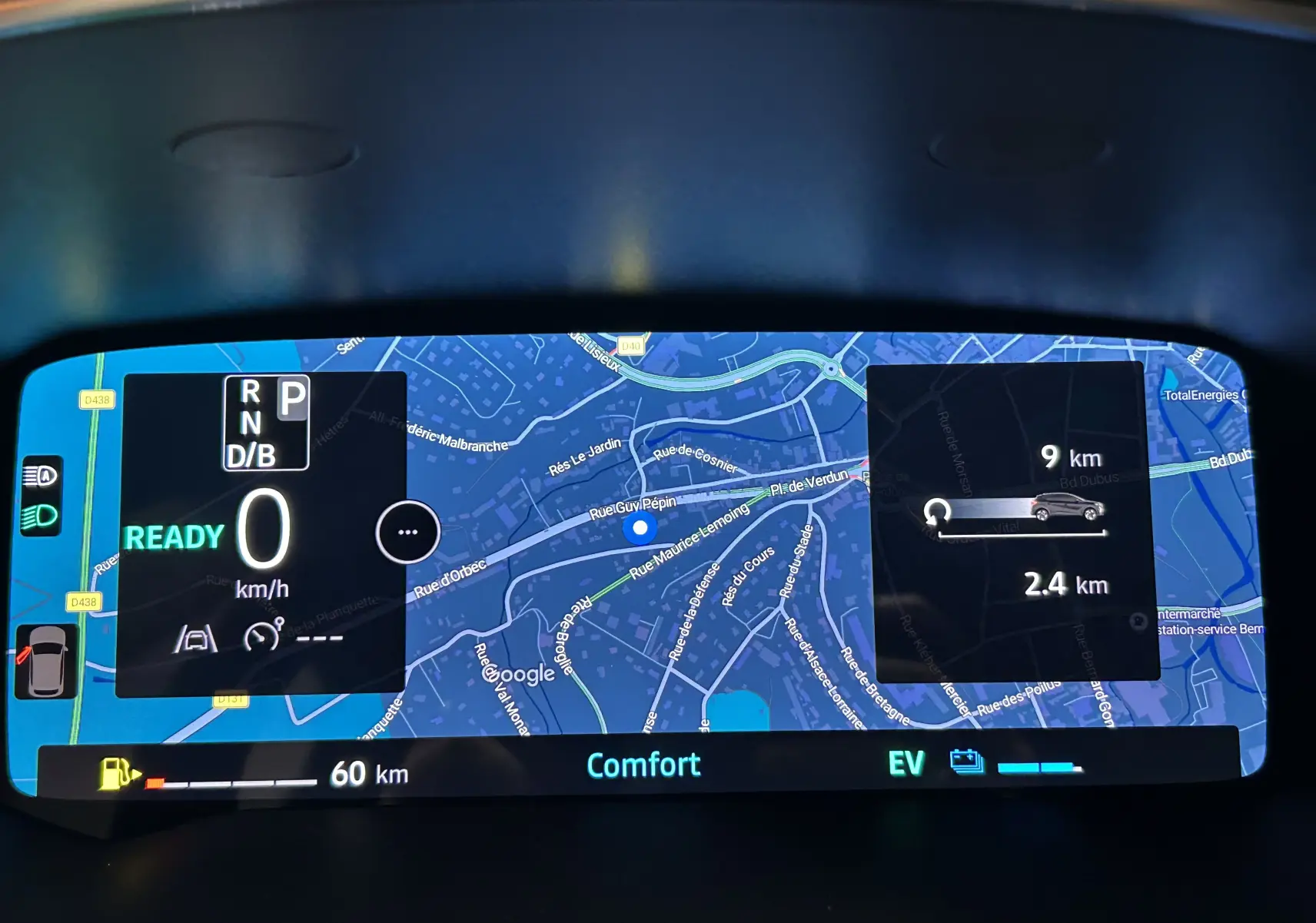 Tableau de bord numérique du Renault Captur blanc nacré, affichant la navigation et l'état hybride en mode confort.