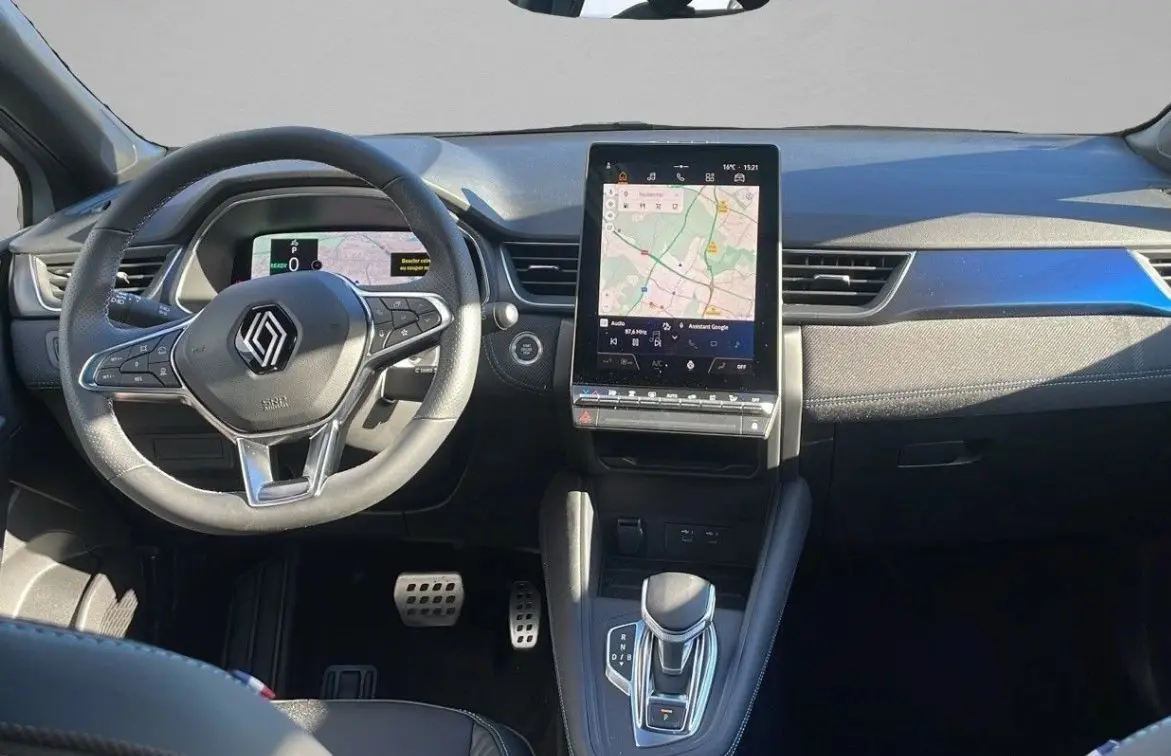 Vue intérieure frontale du tableau de bord du Renault Captur blanc nacré avec écran tactile vertical et volant multifonction.