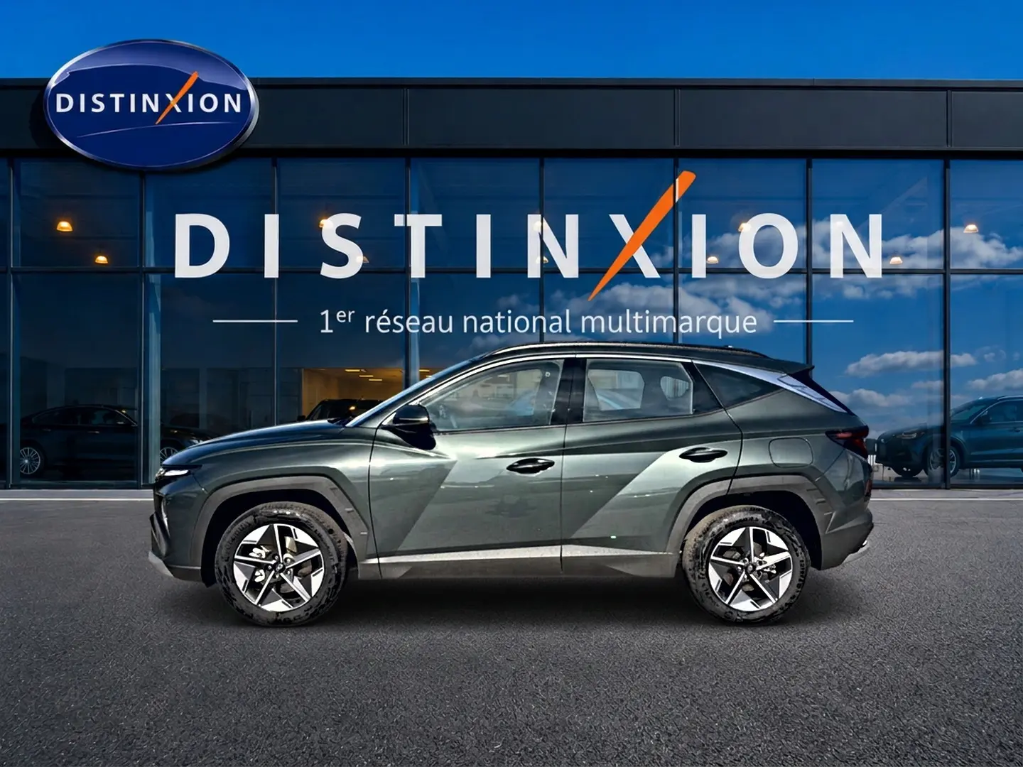 Vue de profil côté gauche d'un Hyundai Tucson 2026 vert métallisé devant une vitrine Distinxion.