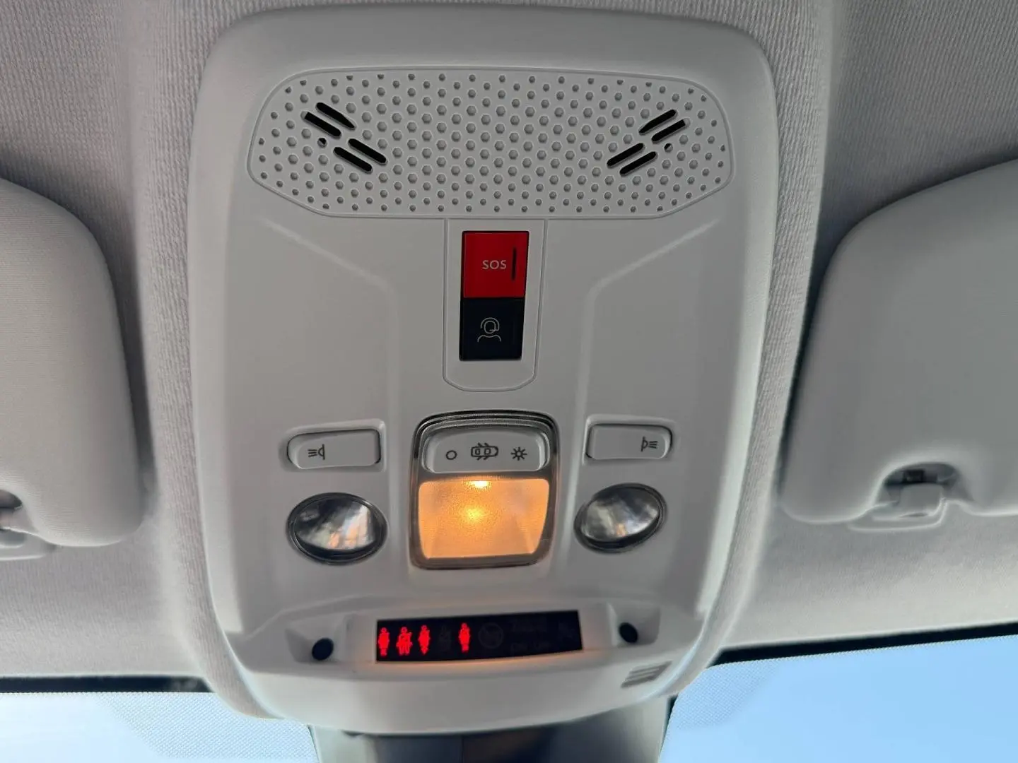 Plafonnier intérieur avec éclairage et boutons SOS de la Peugeot 208 gris Artense, vue en contre-plongée.