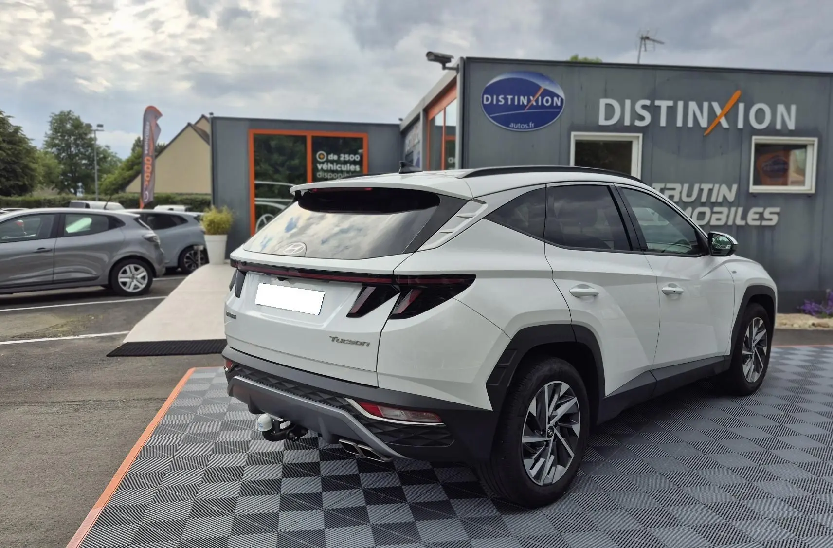 Vue 3/4 arrière droite d’un Hyundai Tucson blanc 2022 avec hayon fermé et feux arrière LED distinctifs.