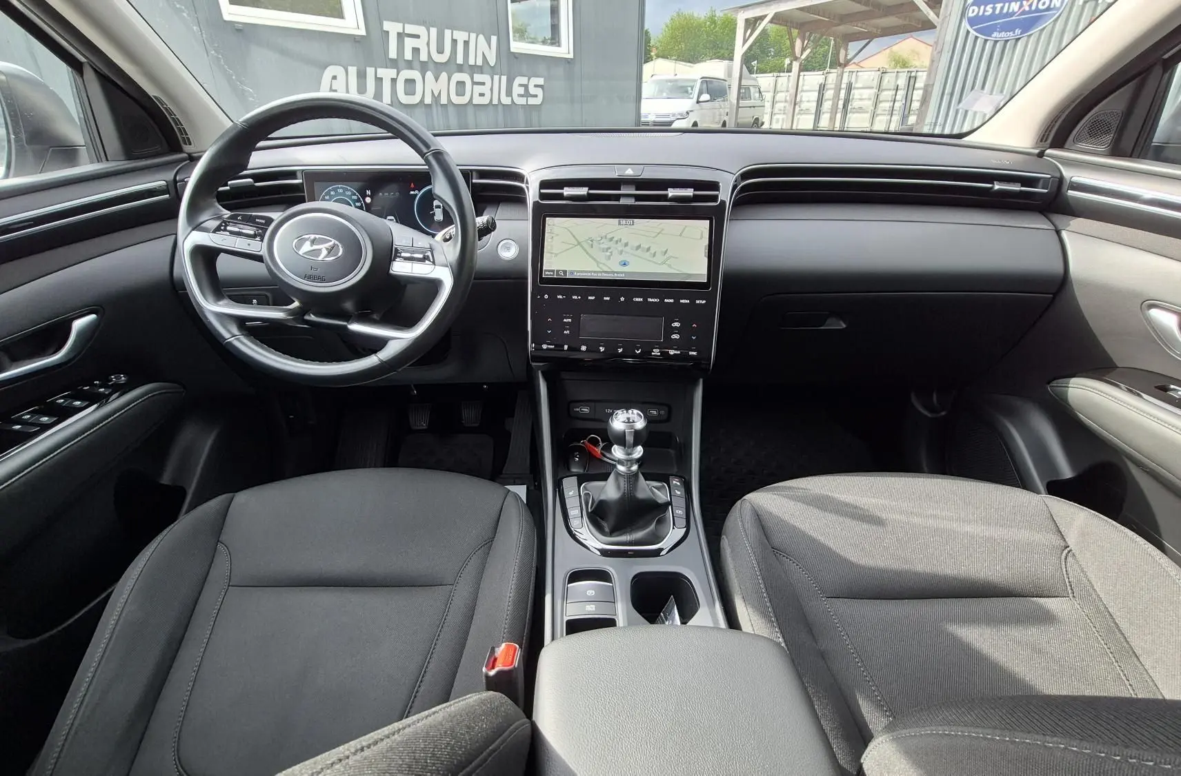 Vue intérieure avant du Hyundai Tucson 1.6 CRDI 136 Creative 2022, volant multifonction et console centrale avec boîte manuelle.