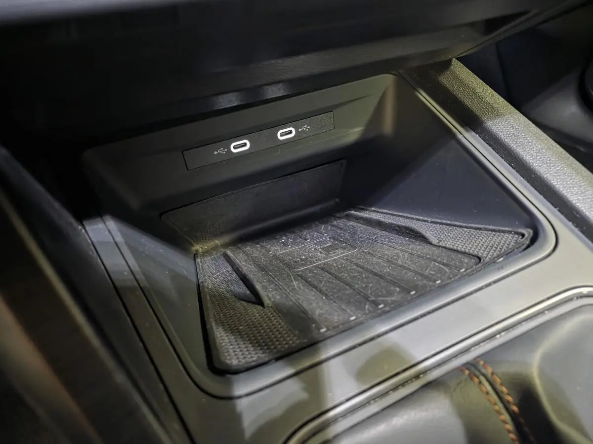 Gros plan sur la console centrale noire du CUPRA Formentor 2023 avec deux prises USB-C éclairées et tapis antidérapant.