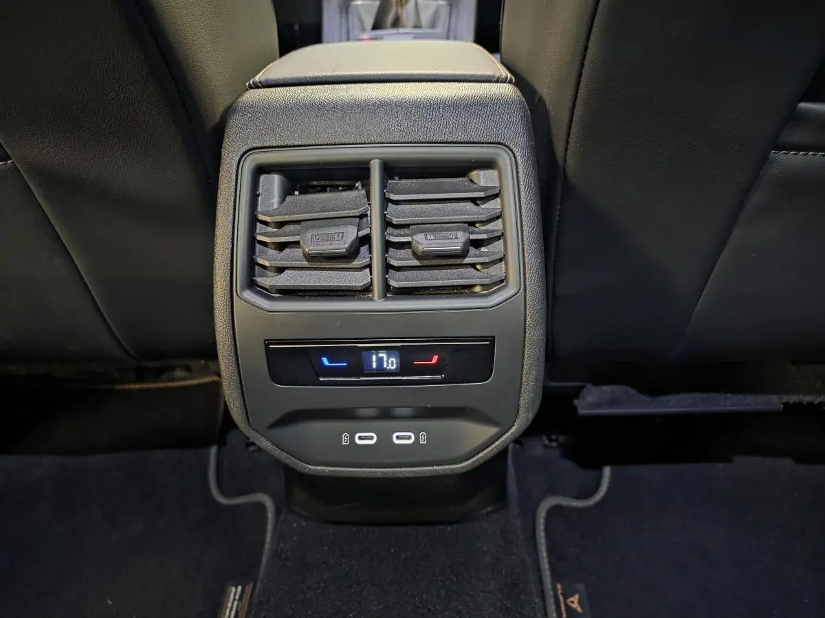 Détail de la console arrière noire avec ventilation, réglage de climatisation à 17°C et deux ports USB-C éclairés.