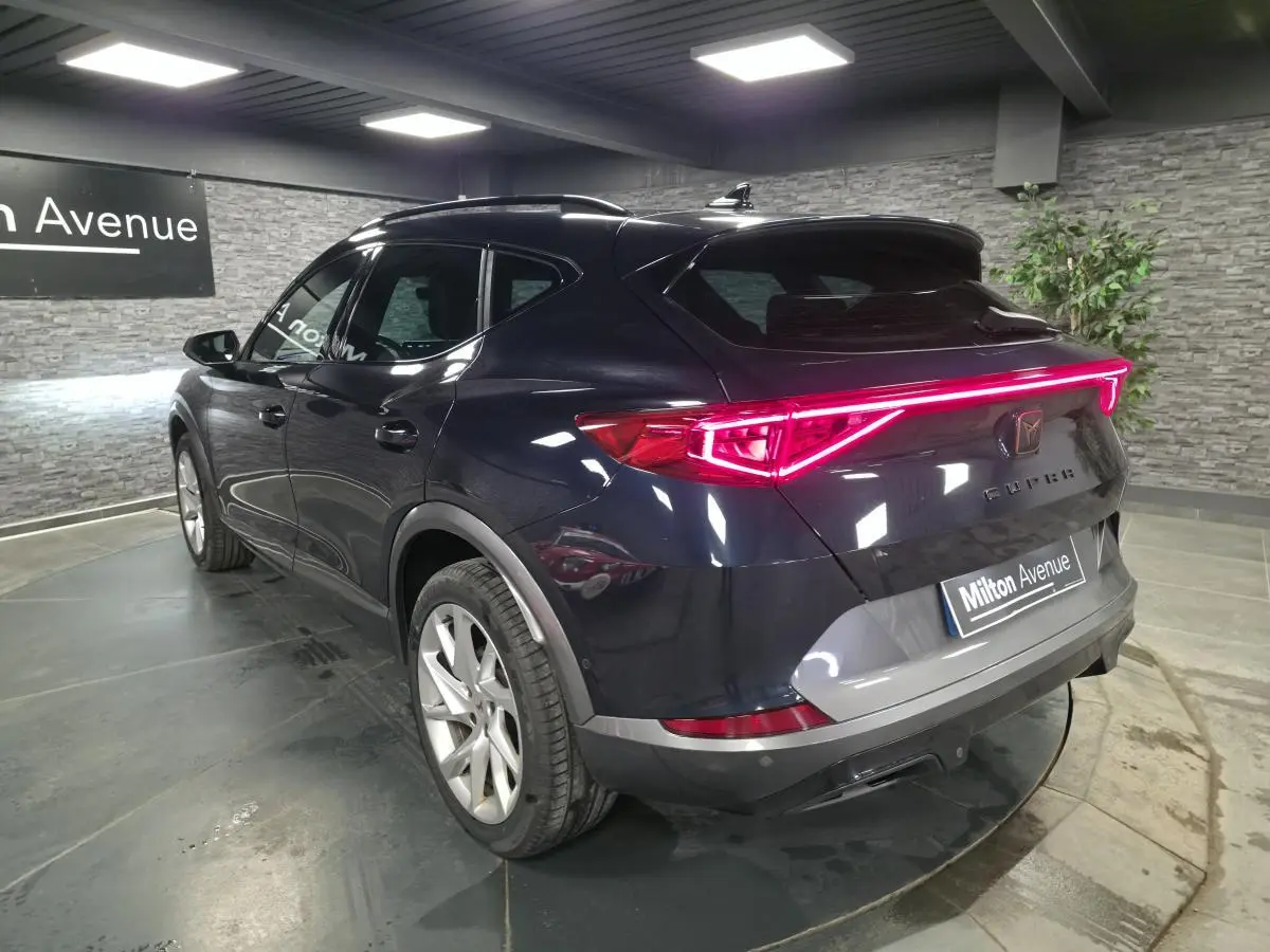 Vue 3/4 arrière du CUPRA Formentor bleu pétrole avec bandeau lumineux arrière LED et jantes alliage 18 pouces.