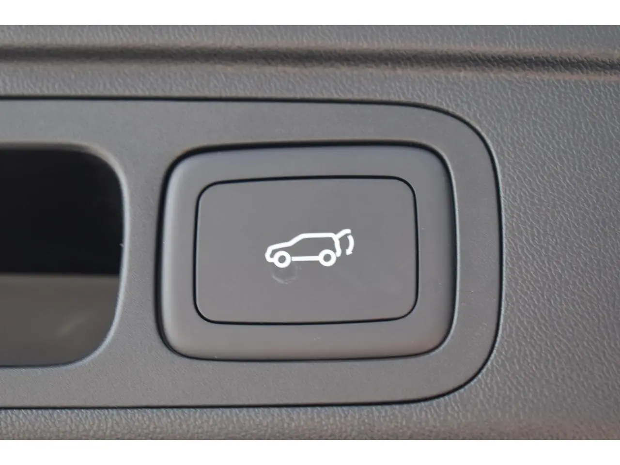 Bouton intérieur noir avec symbole blanc d'ouverture du coffre, sur MG MOTOR EHS 1.5 Hybrid+ 224 ch Luxury blanc 2026.