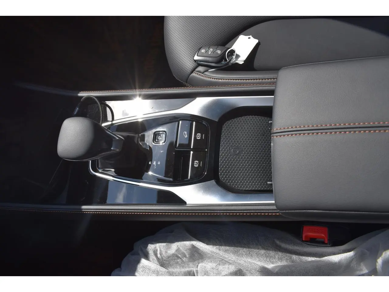 Vue plongeante sur la console centrale noire du MG Motor EHS 1.5 Hybrid+ 224 ch Luxury avec levier de vitesses et clé.