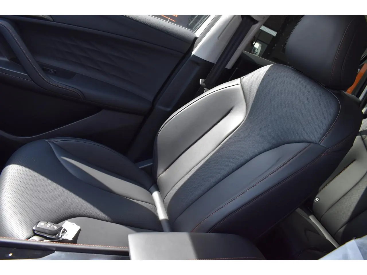 Gros plan sur le siège avant droit en cuir noir avec surpiqûres marron du MG Motor EHS 1.5 Hybrid+ blanc 2026.