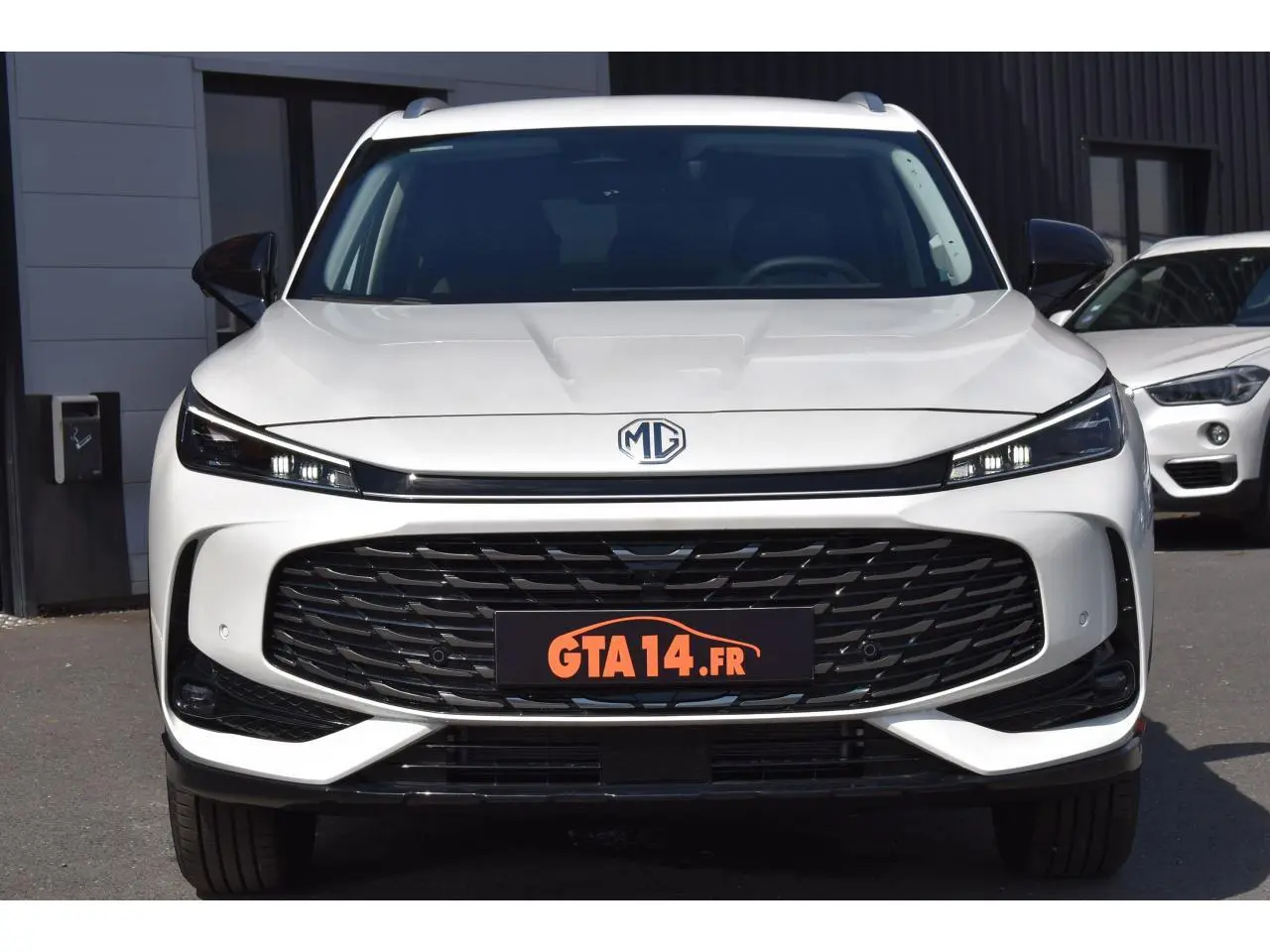 Vue avant d’un MG MOTOR EHS blanc 2026, version Hybrid+ Luxury, avec calandre large et phares LED fins.