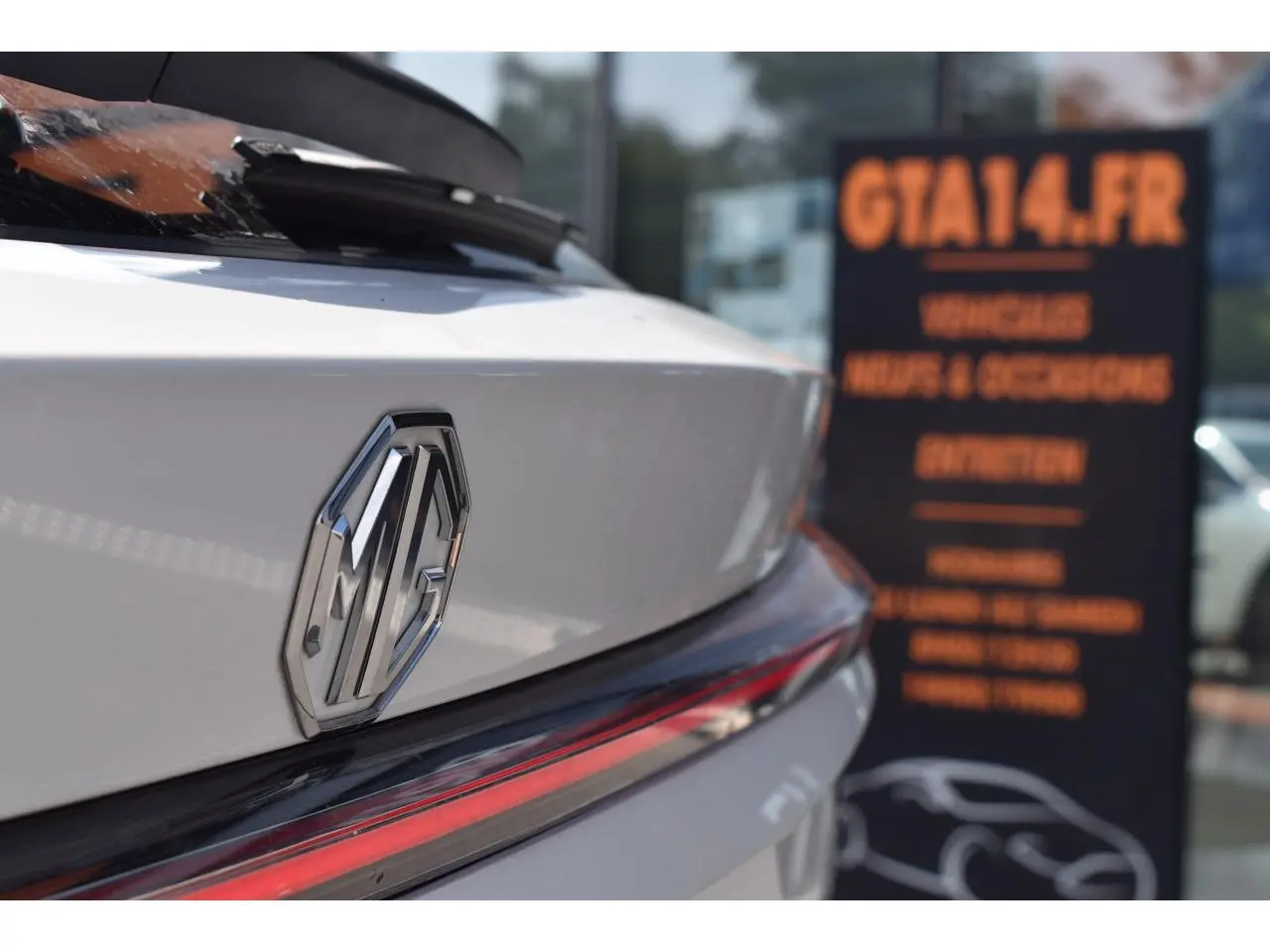 Gros plan sur l'arrière blanc du MG EHS 1.5 Hybrid+ 224 ch Luxury, avec le logo MG et un feu arrière allongé rouge.