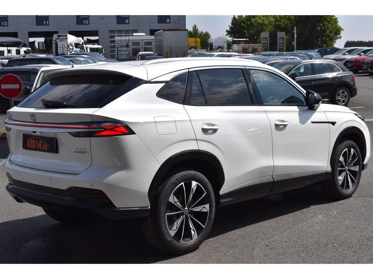 Vue 3/4 arrière droite du MG Motor EHS blanc 2026, hybride, avec feux arrière LED et jantes alliage distinctives.
