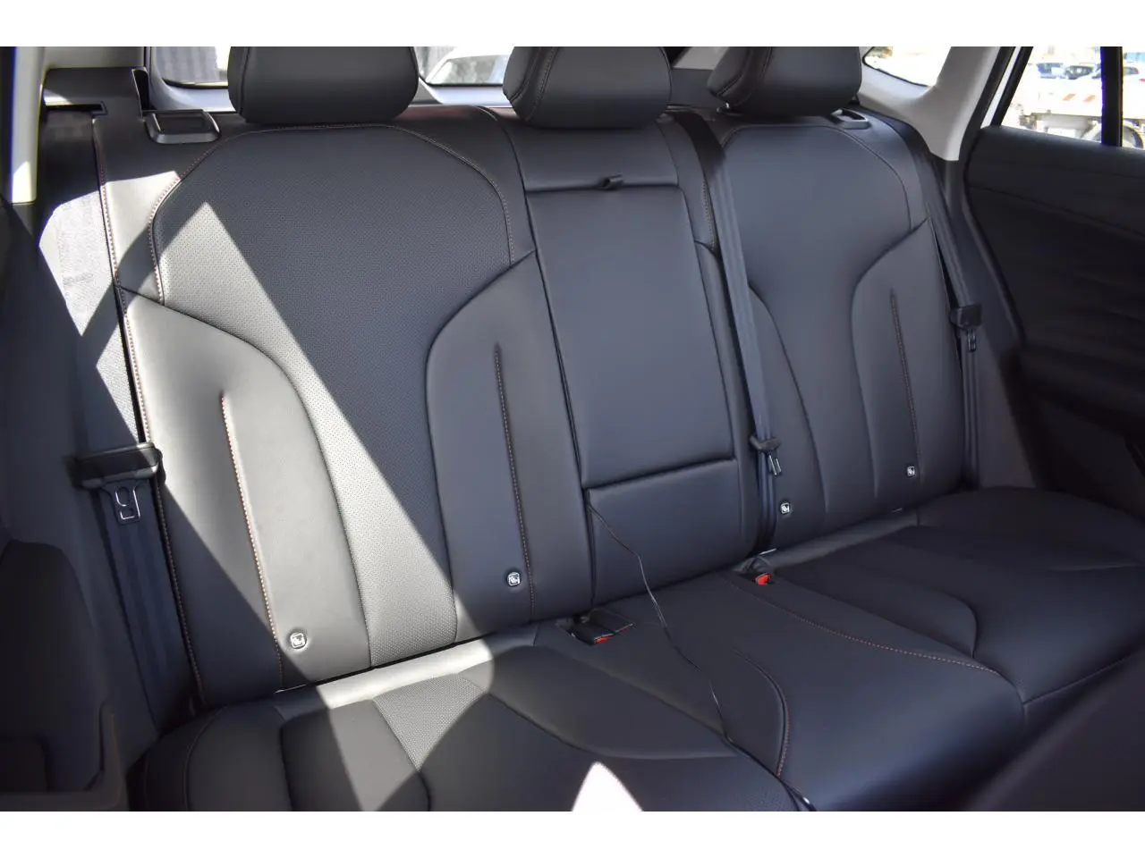 Vue intérieure des sièges arrière en cuir noir avec surpiqûres contrastantes du MG MOTOR EHS 1.5 Hybrid+ 224 ch Luxury 2026.