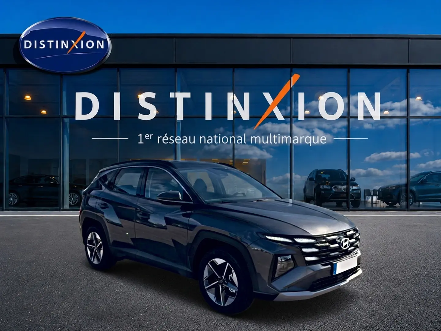 Hyundai Tucson gris ecotonic en 3/4 avant droit devant une vitrine avec logo Distinxion.