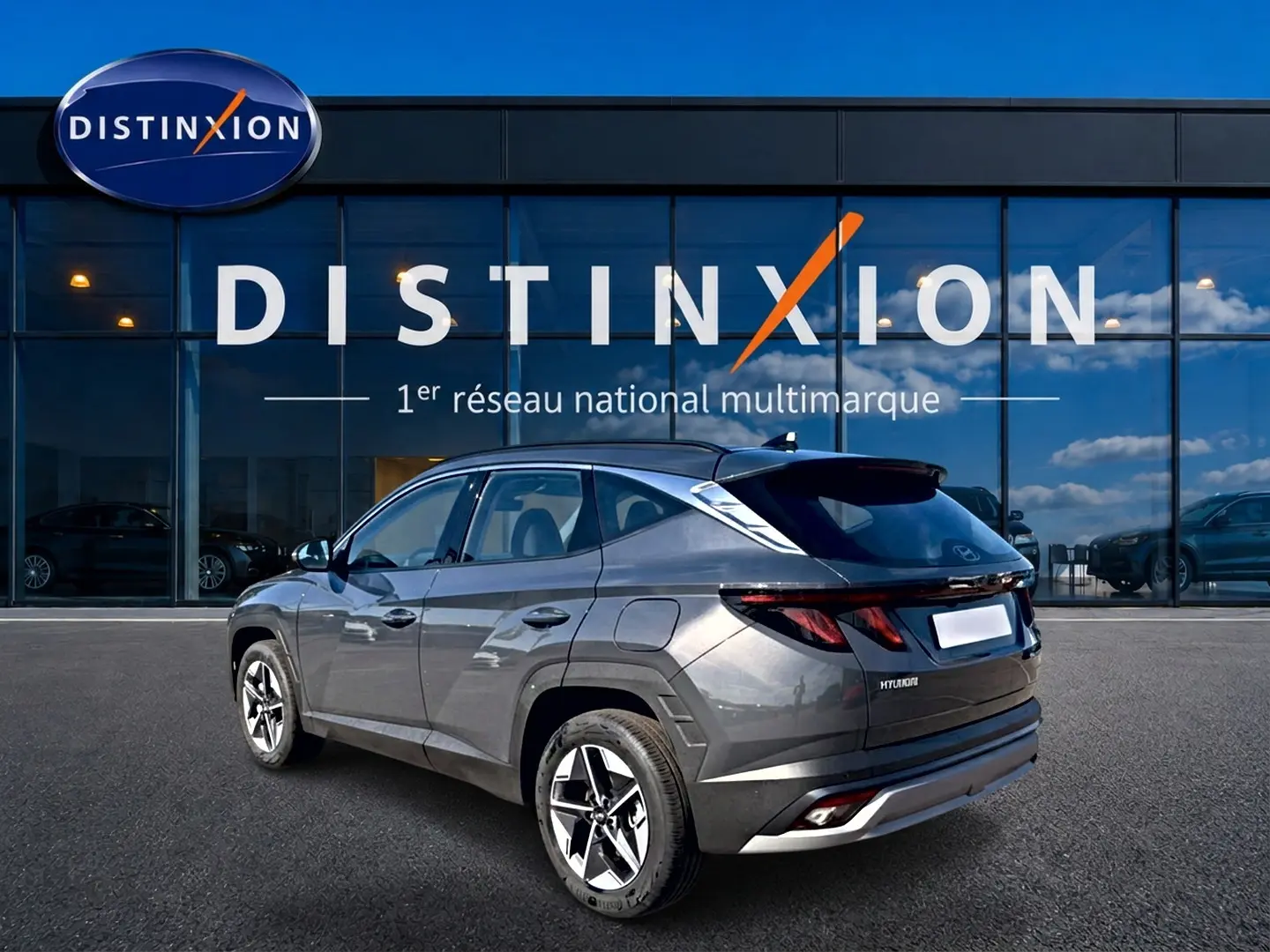 Hyundai Tucson gris écotonic vu en 3/4 arrière droit, avec jantes alu et feux arrière LED distinctifs.