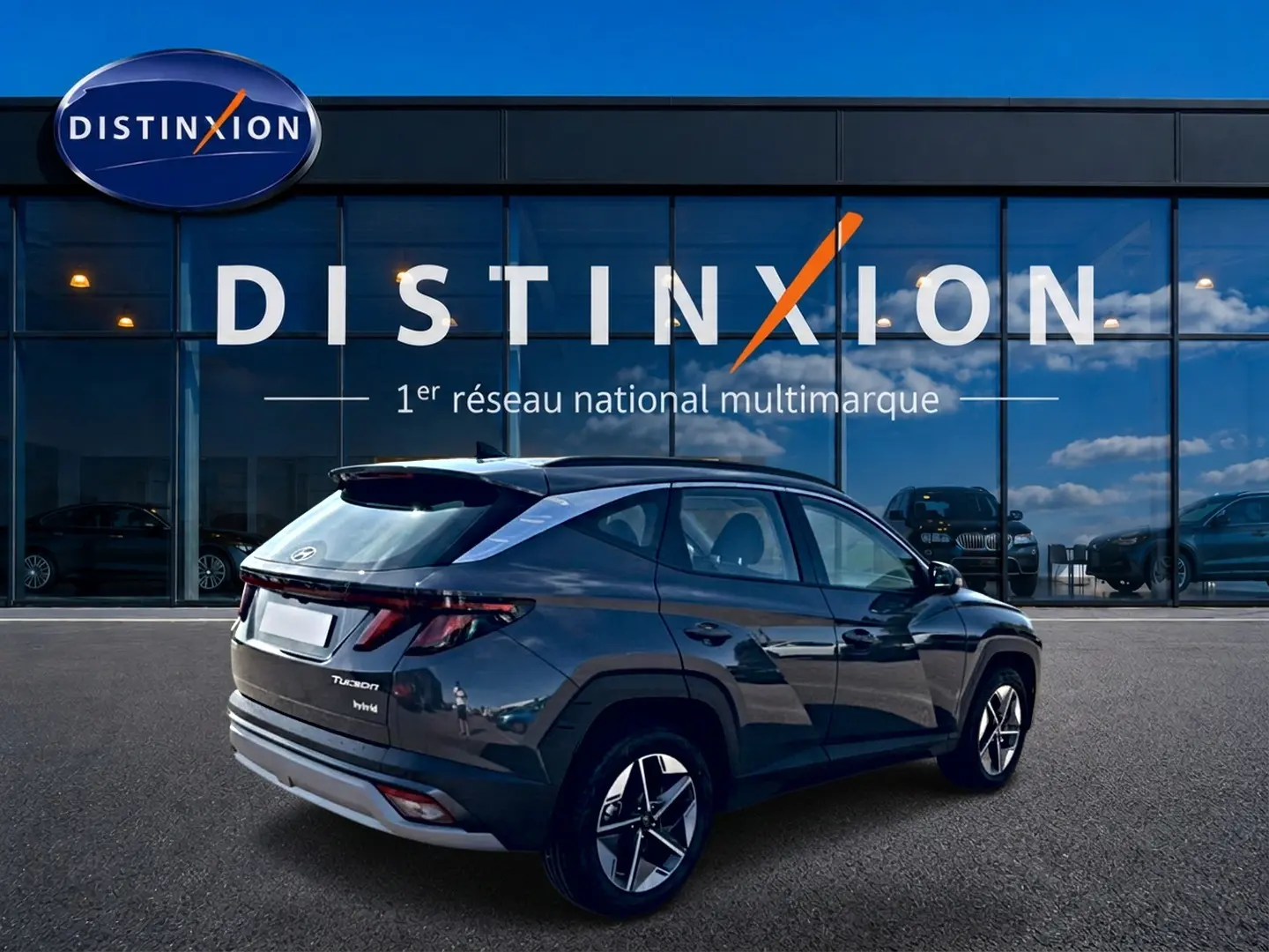 Hyundai Tucson gris ecotonic en 3/4 arrière droit, avec jantes alu et feux arrière LED distinctifs.