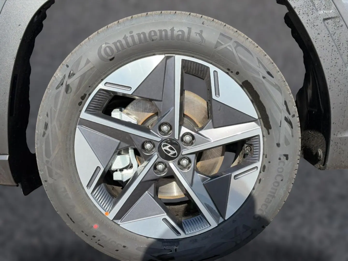 Gros plan sur la jante alu 18 pouces à cinq branches du Hyundai Tucson gris ecotonic, avec logo central Hyundai visible.